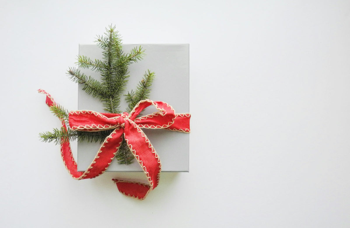 White Christmas gift box tied with a red ribbon