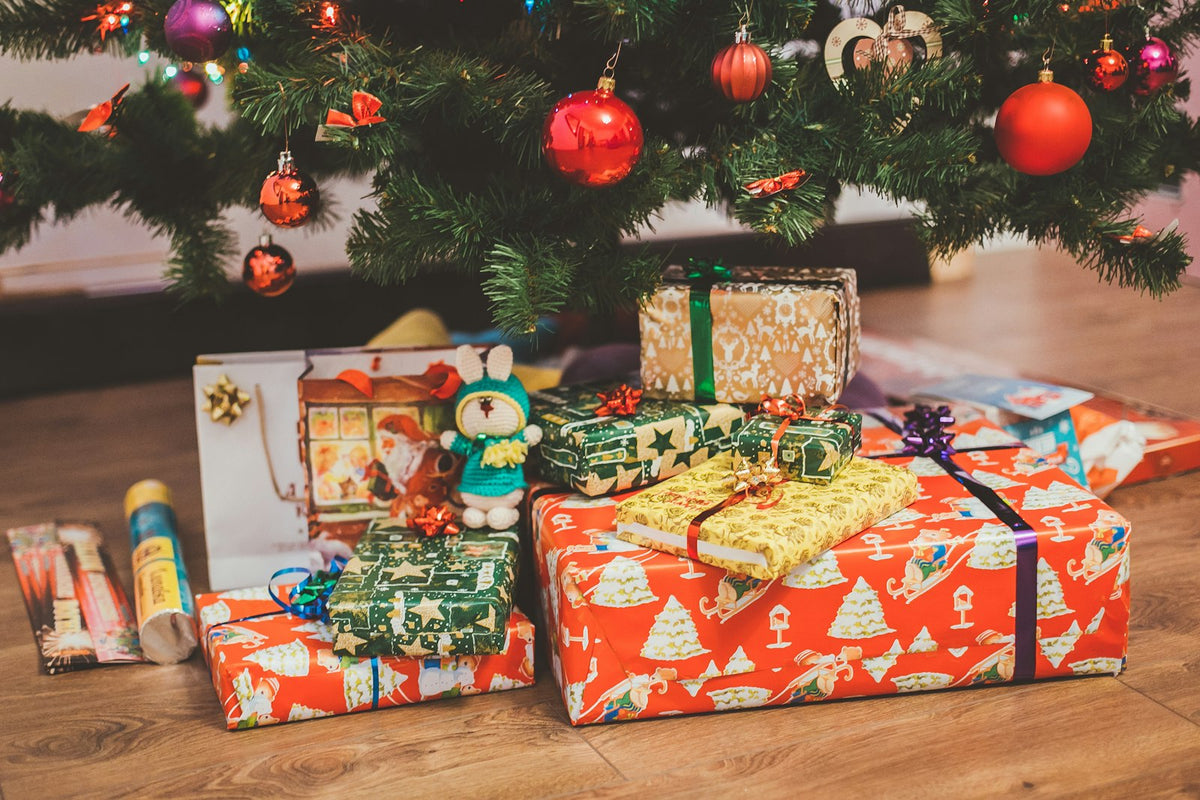Regalos envueltos con papeles de colores bajo el árbol de Navidad
