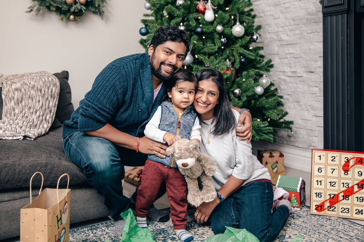 Famille souriante devant le sapin de Noël